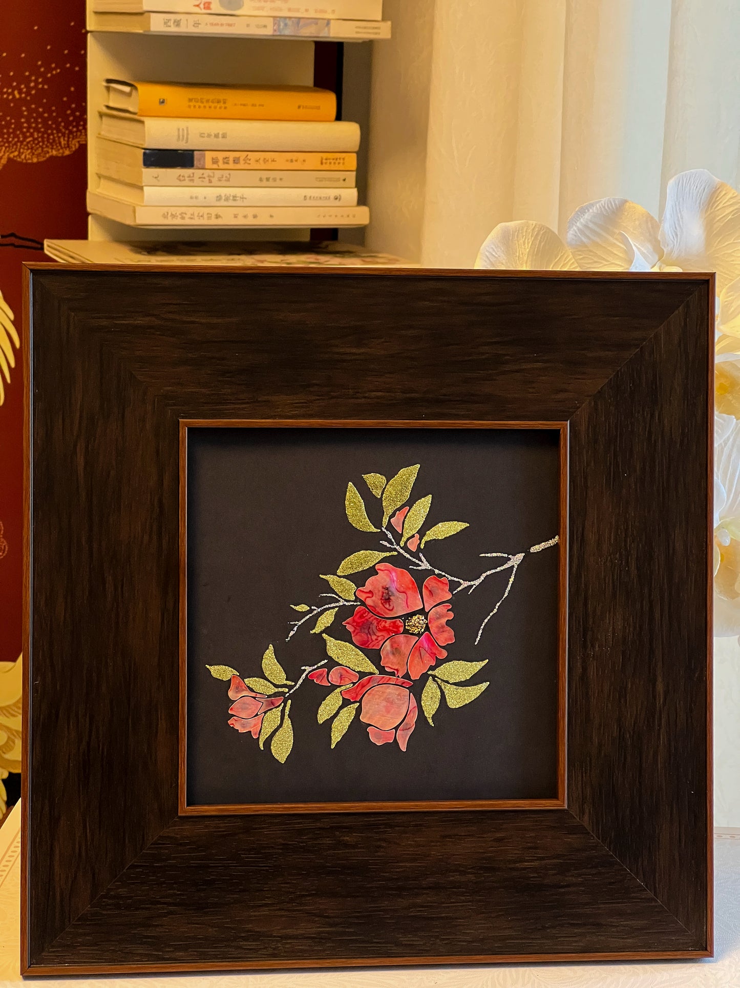 Original Raden shell art titled The Pomegranate Blossom by Showing Studio in a 35x35cm wide margin dark walnut frame, showcasing iridescent crimson mother of pearl petals and gold-lime abalone leaves