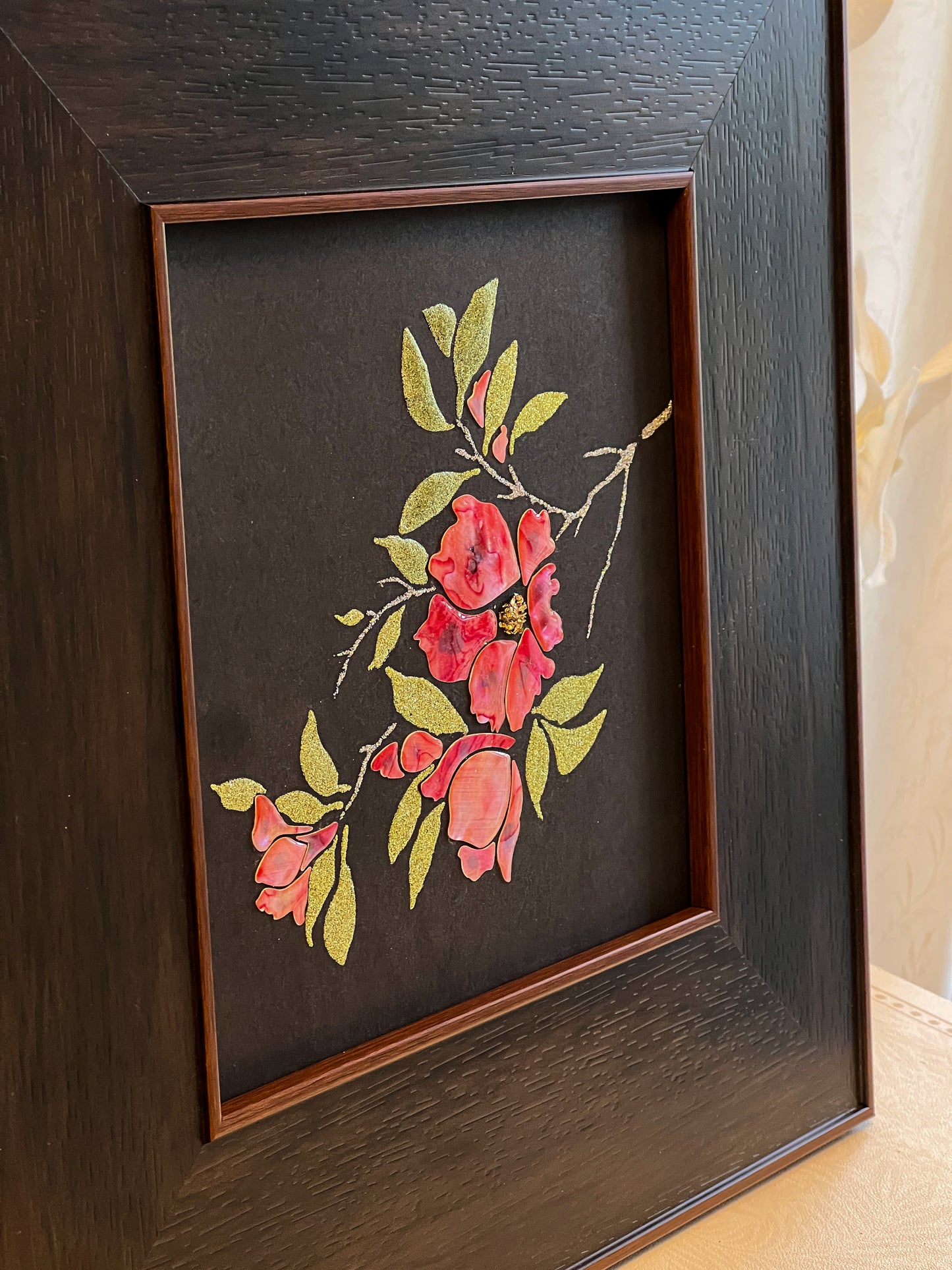Original Raden shell art titled The Pomegranate Blossom by Showing Studio in a 35x35cm wide margin dark walnut frame, showcasing iridescent crimson mother of pearl petals and gold-lime abalone leaves