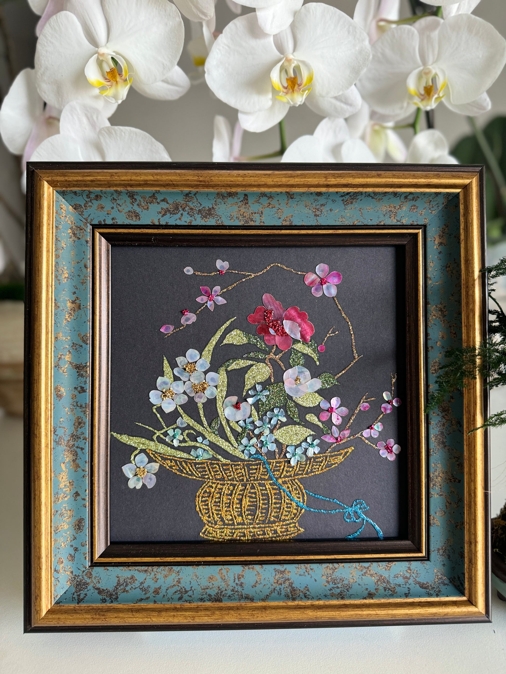 Luxury Zen home decor presentation featuring the "Three Friends of Winter" oriental shell artwork displayed next to a minimalist green kokedama bonsai plant.