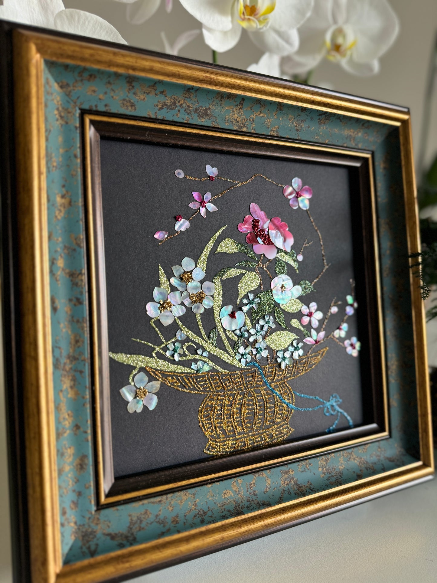 Close-up shot of traditional Raden inlay technique showing the dynamic iridescent luster of natural abalone shell petals and golden wire weave details on a black background.