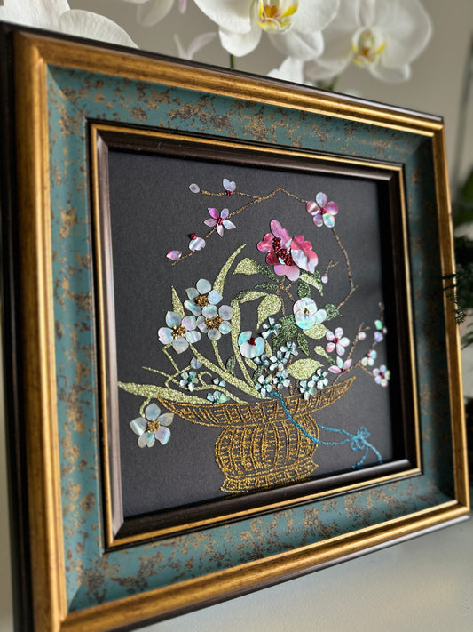 Close-up shot of traditional Raden inlay technique showing the dynamic iridescent luster of natural abalone shell petals and golden wire weave details on a black background.