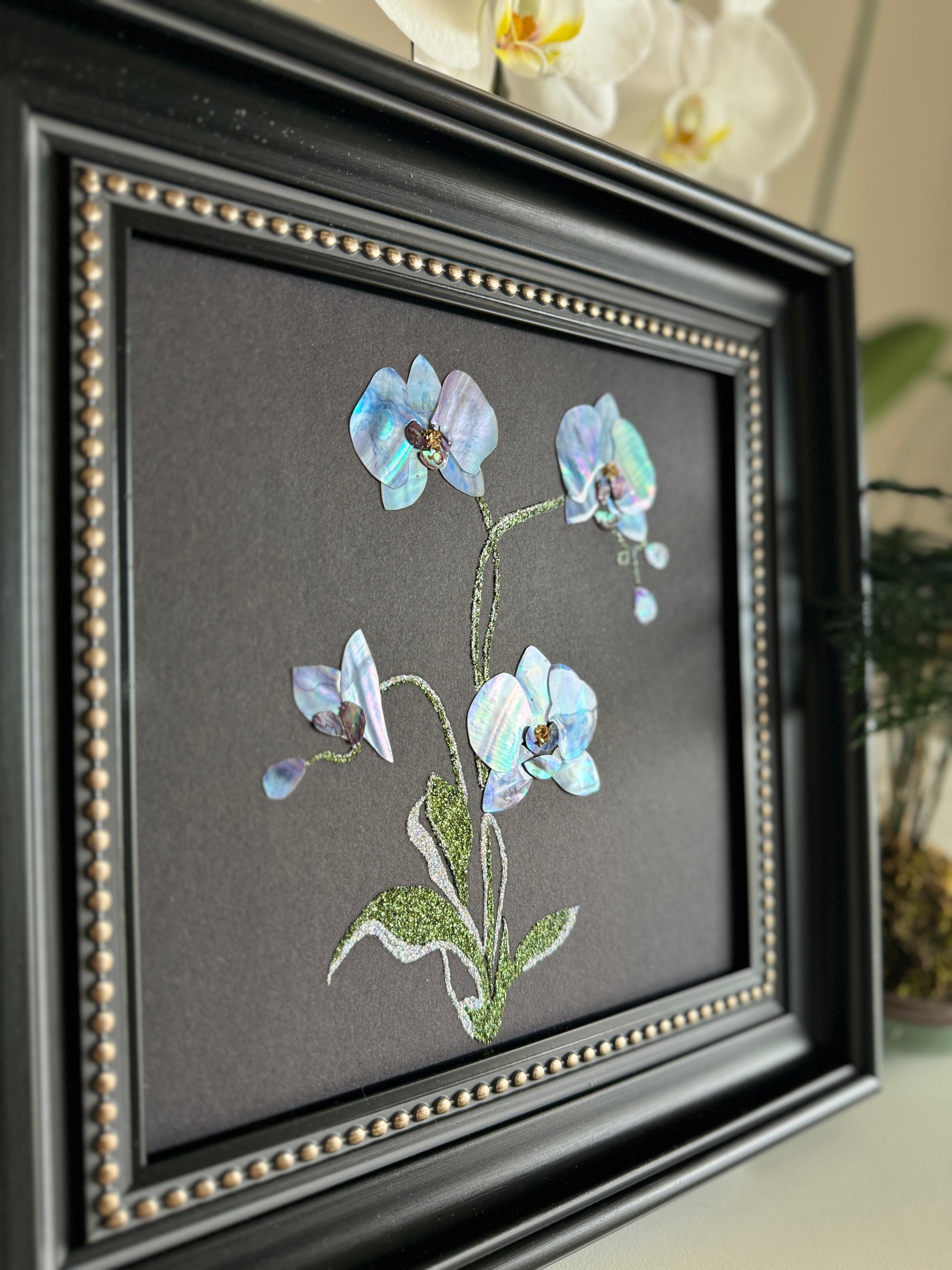 Original abstract Raden shell art titled The Azure Rhythm by Showing Studio in a 29x29cm dark walnut frame, showcasing shimmering green and blue abalone inlay waves on a black background.