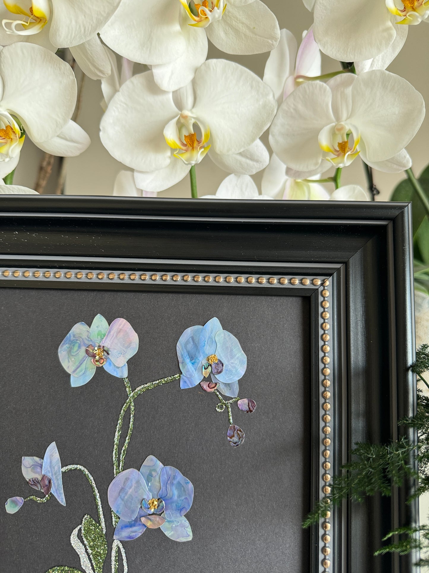 Original abstract Raden shell art titled The Azure Rhythm by Showing Studio in a 29x29cm dark walnut frame, showcasing shimmering green and blue abalone inlay waves on a black background.