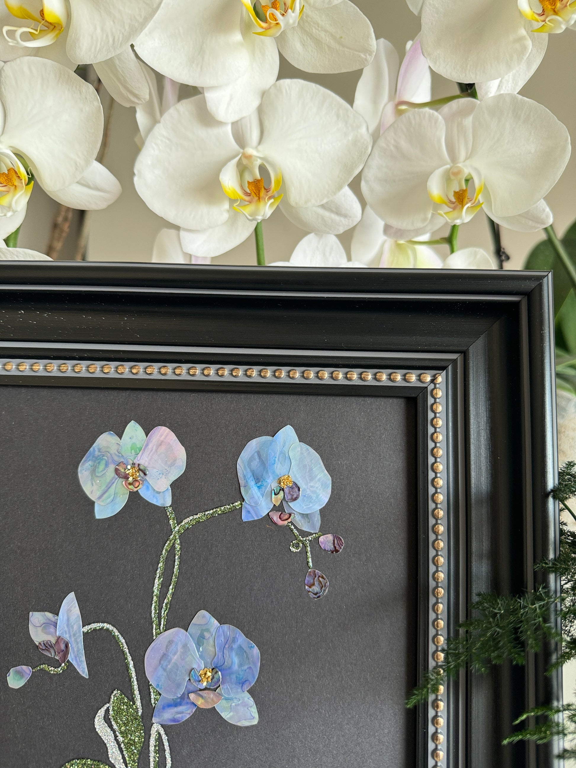 Original abstract Raden shell art titled The Azure Rhythm by Showing Studio in a 29x29cm dark walnut frame, showcasing shimmering green and blue abalone inlay waves on a black background.