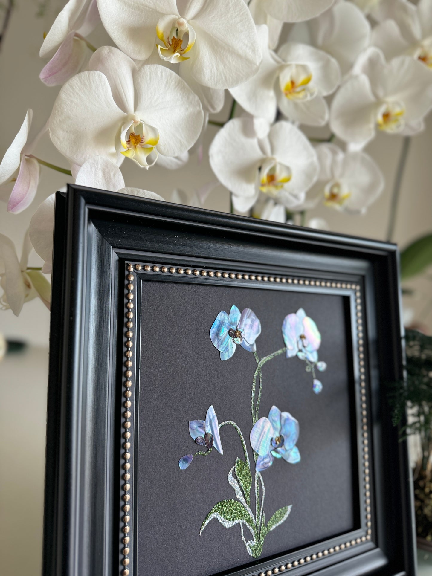 Original abstract Raden shell art titled The Azure Rhythm by Showing Studio in a 29x29cm dark walnut frame, showcasing shimmering green and blue abalone inlay waves on a black background.