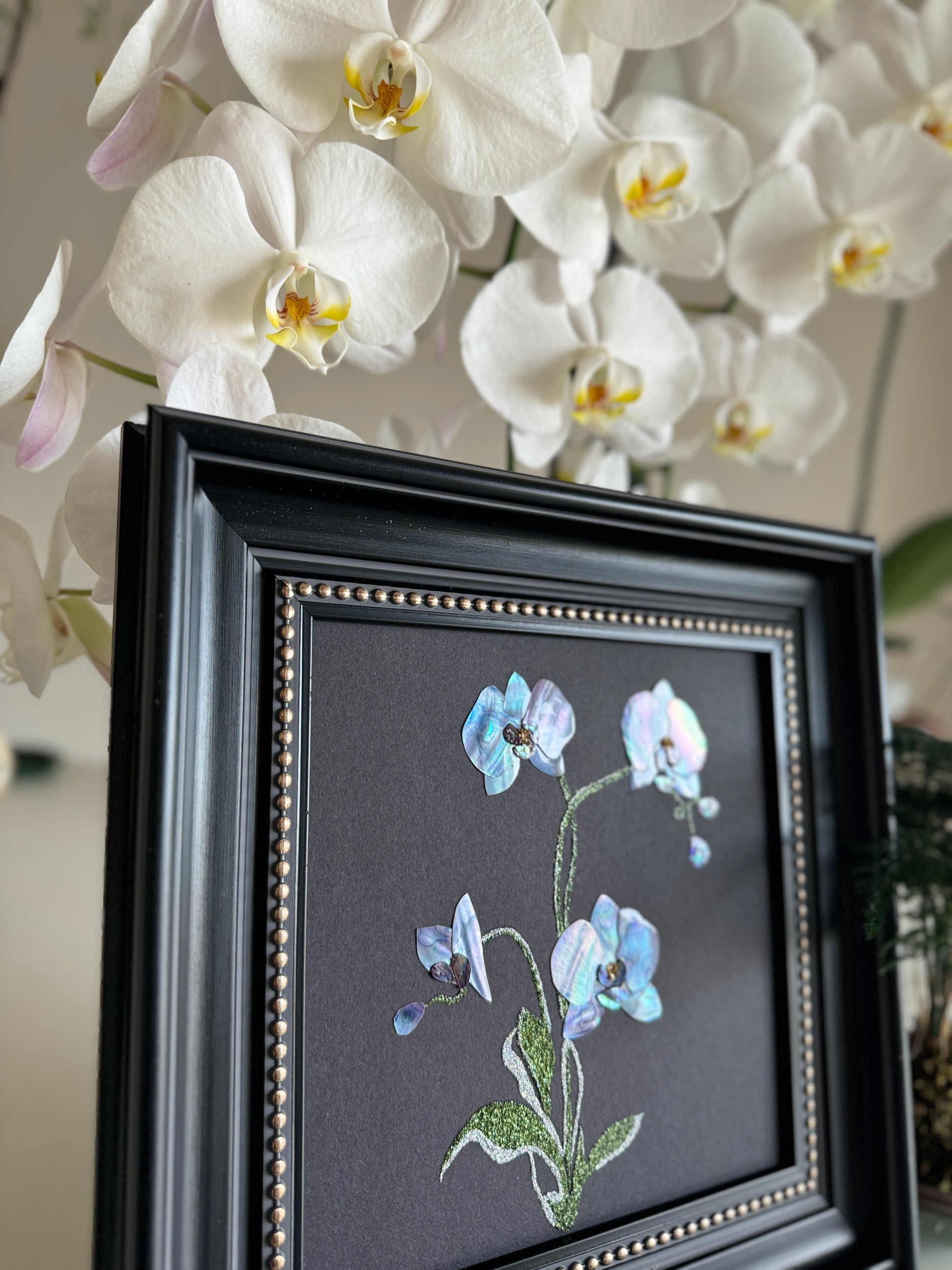 Original abstract Raden shell art titled The Azure Rhythm by Showing Studio in a 29x29cm dark walnut frame, showcasing shimmering green and blue abalone inlay waves on a black background.