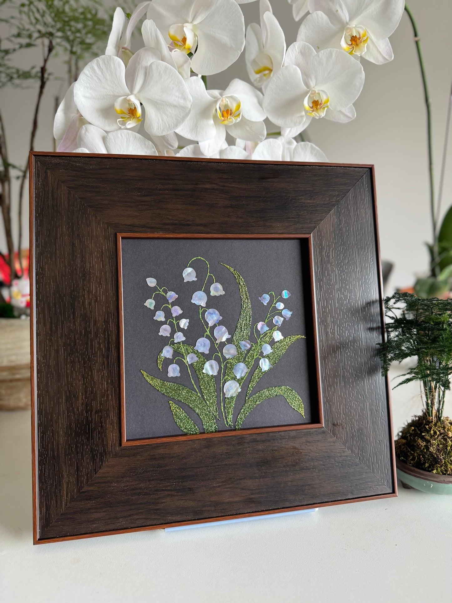 Handcrafted "Whispers of Lily" mother-of-pearl wall art, 20x20cm floral inlay, luxury botanical Zen home decor.