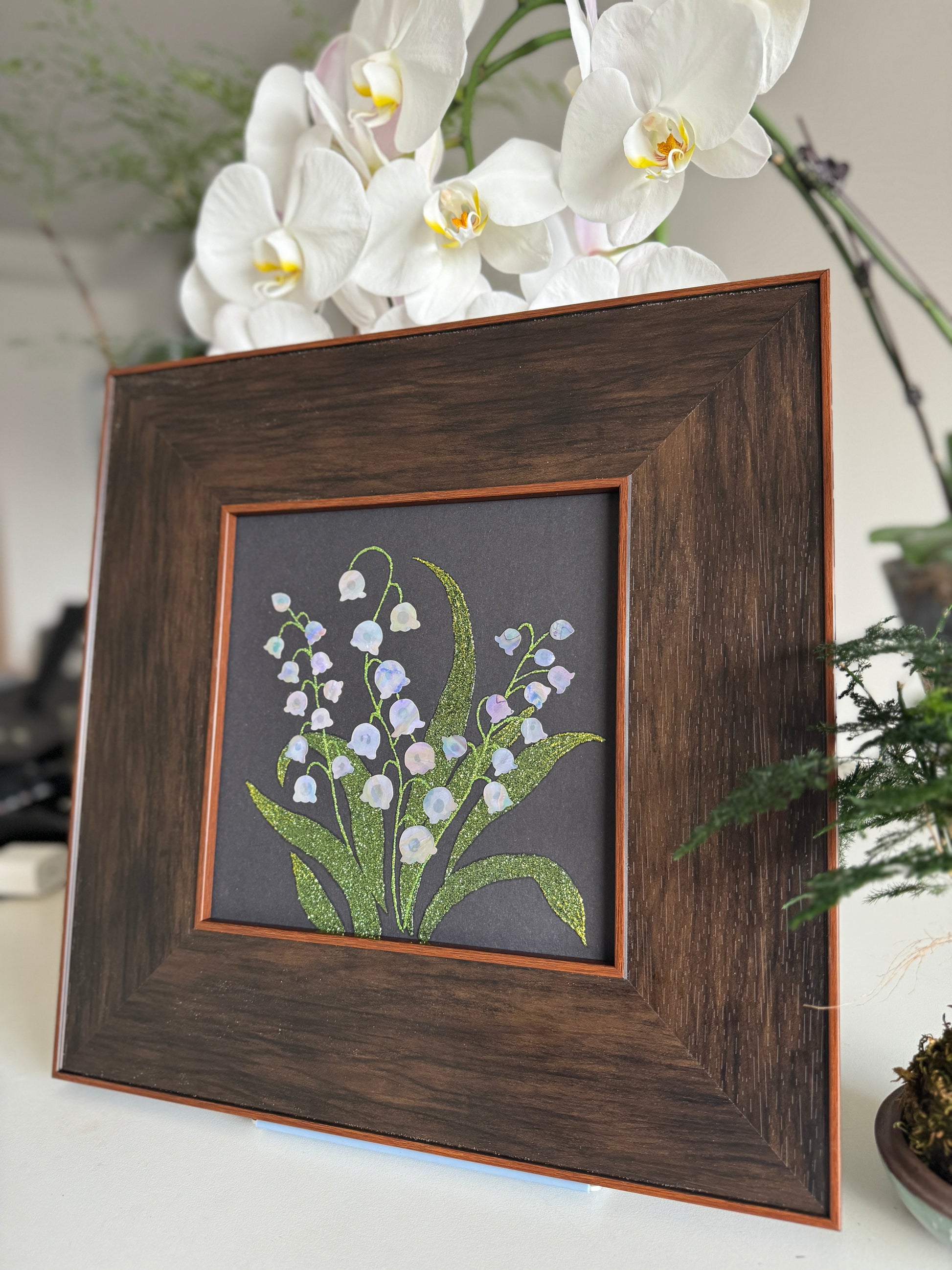 Handcrafted "Whispers of Lily" mother-of-pearl wall art, 20x20cm floral inlay, luxury botanical Zen home decor.