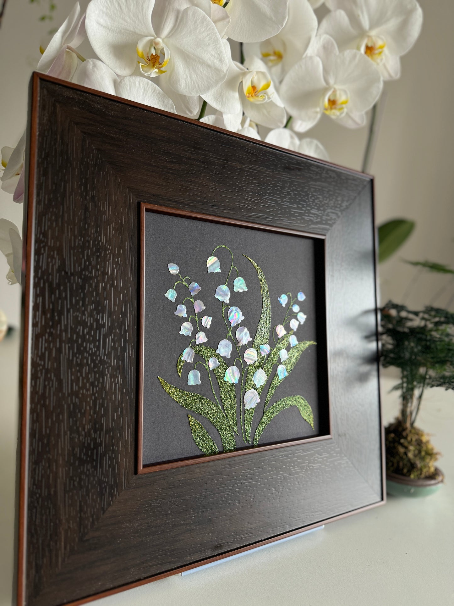 Handcrafted "Whispers of Lily" mother-of-pearl wall art, 20x20cm floral inlay, luxury botanical Zen home decor.