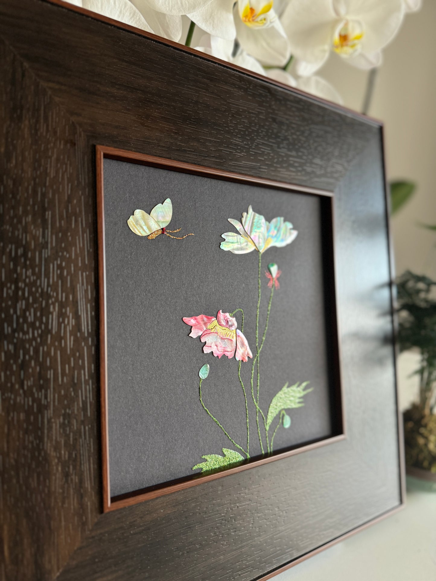 Macro close up of mother of pearl poppy flower art showing intense iridescent rose and pink luster, fine golden stamen details, and detailed mosaic leaf textures.