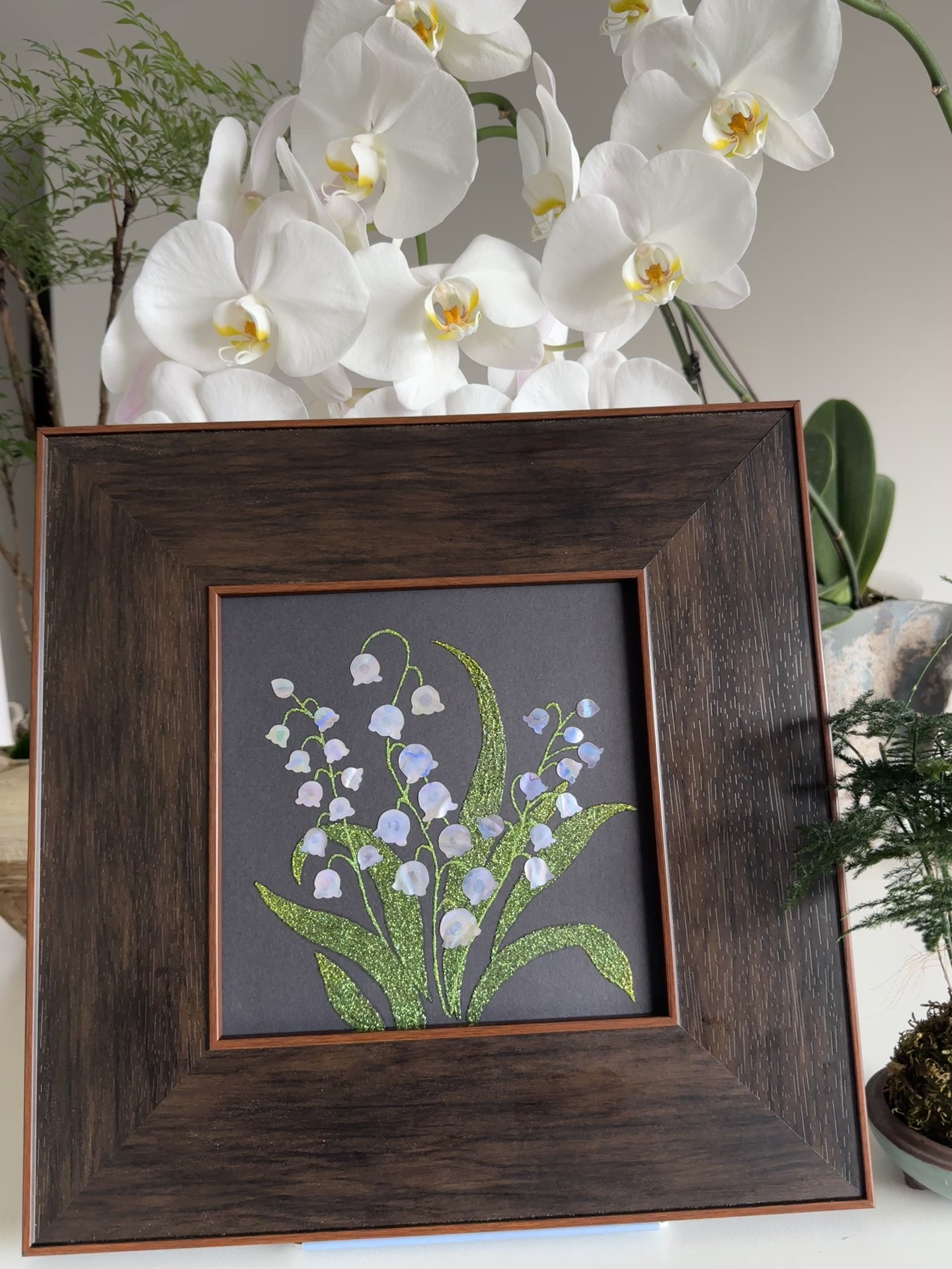 Handcrafted "Whispers of Lily" mother-of-pearl wall art, 20x20cm floral inlay, luxury botanical Zen home decor.